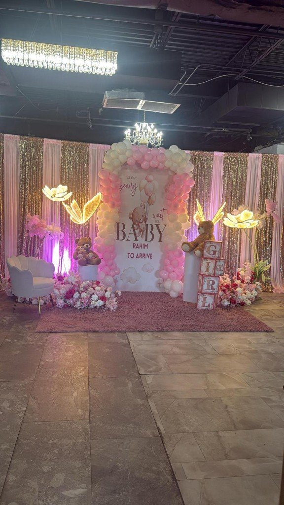 Baby shower setup with teddy bears, floral lamps, and GIRL letter blocks
