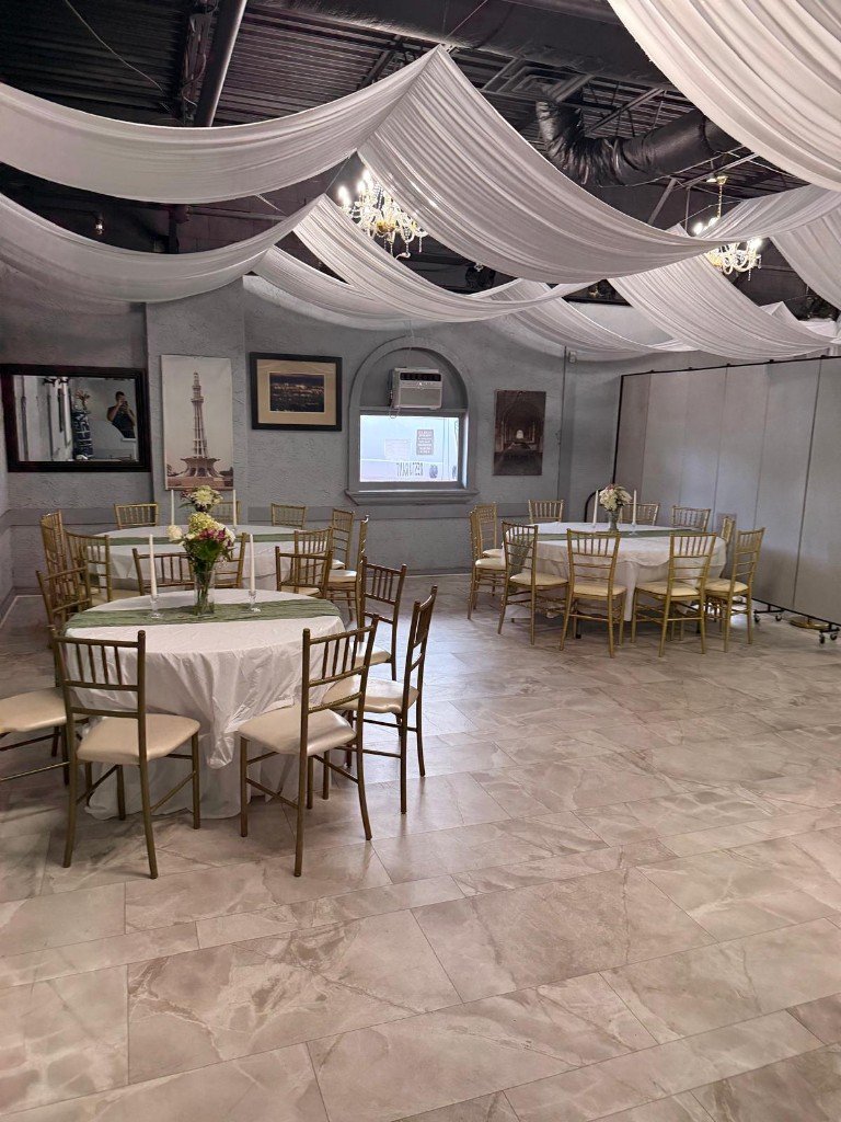 Banquet dining tables with white linens and gold Chiavari chairs