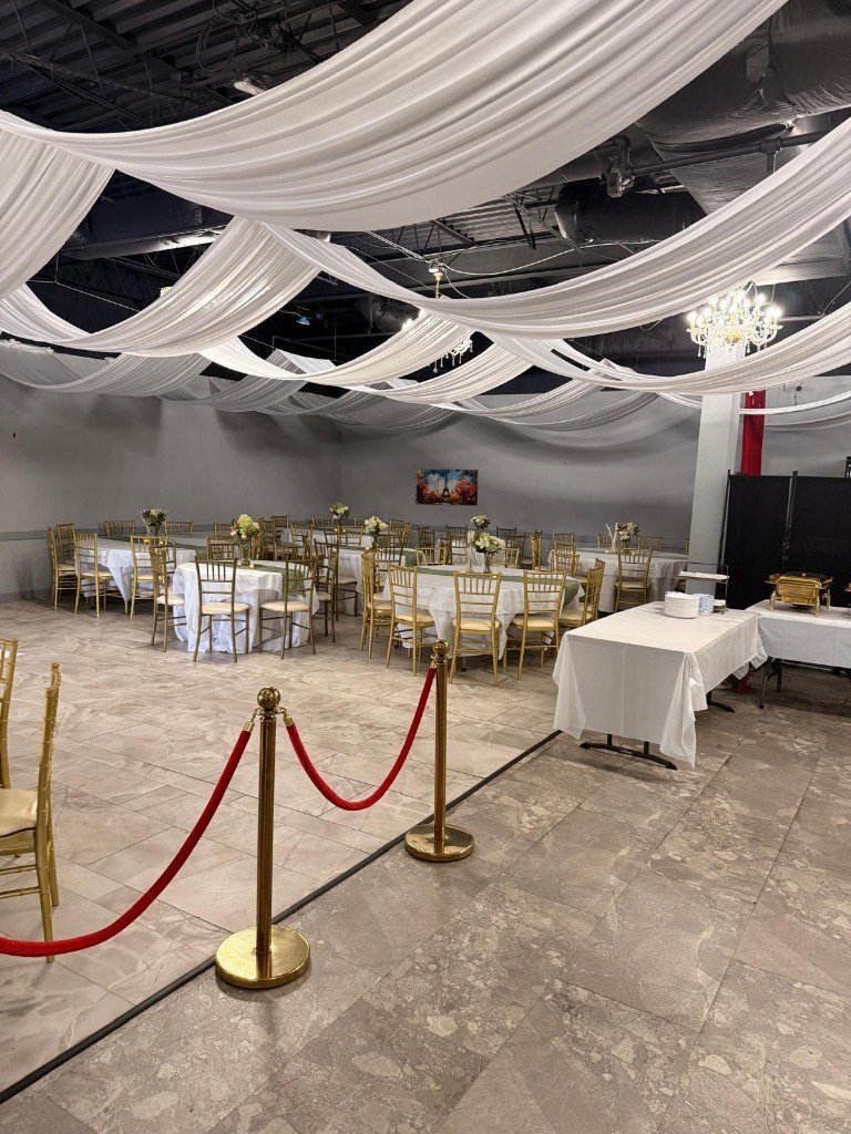 Full banquet hall with draped ceiling and formal table settings