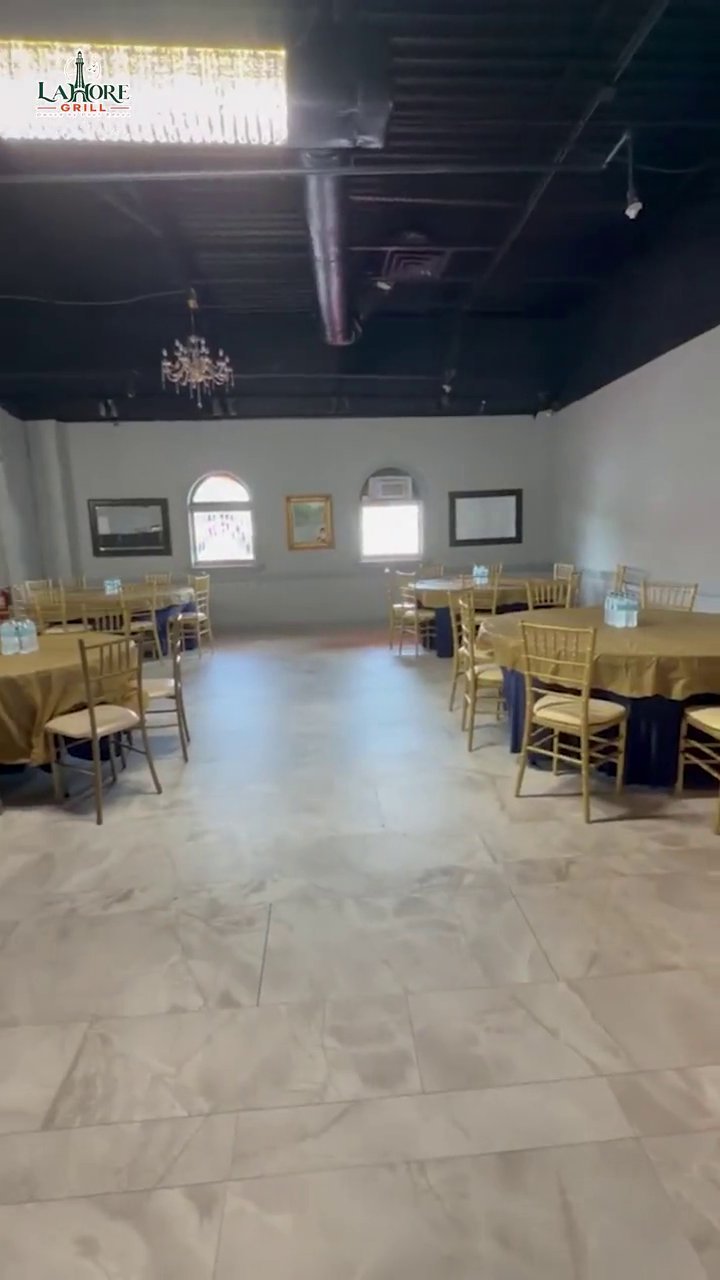 Video pan across the empty Lahore Grill banquet hall set with gold tables and chairs